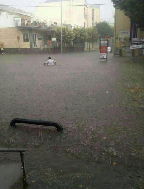 Nubifragio Sud Barese - Nubifragio Acquaviva delle Fonti l´avventuriero Vincenzo che tenta di attaversare la strada a Piazza Kennedy completamente allagata... per cercare di sposta la sua macchina dall'alluvione e da una forte grandinata. Immagini del 14 Giugno 2014 width=